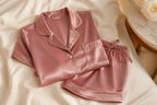 Vela Signature pearl-trim satin pajama set in dusty rose folded on soft bedding